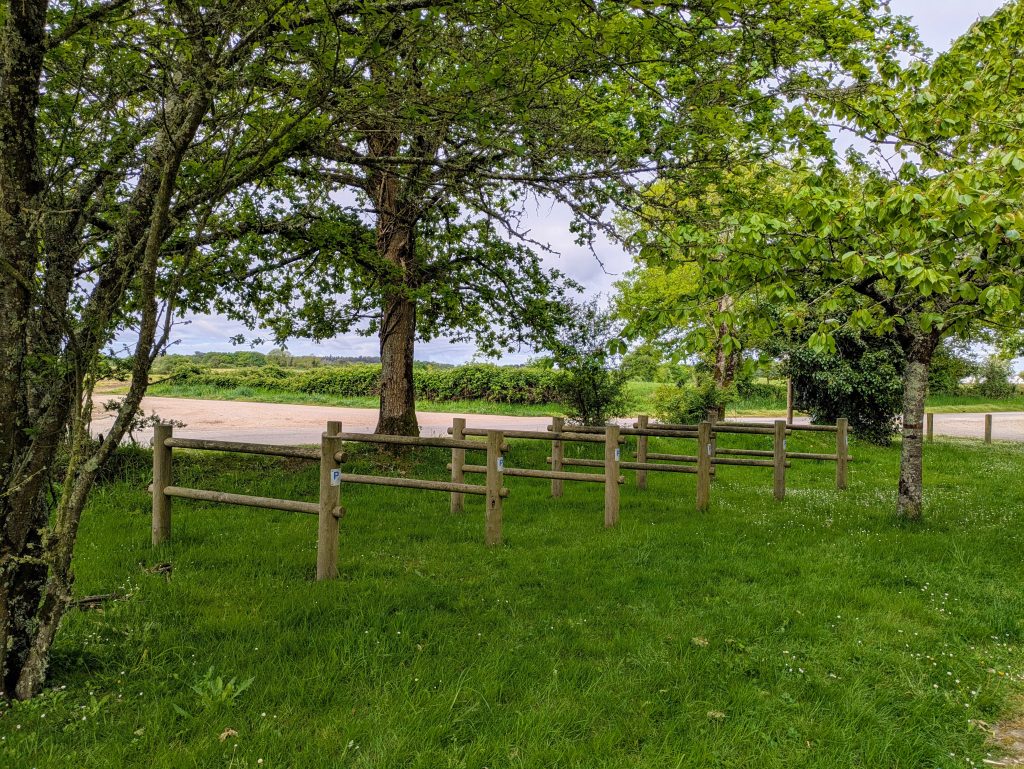 Aire de vélo avec des barrières en bois entourées d’arbres