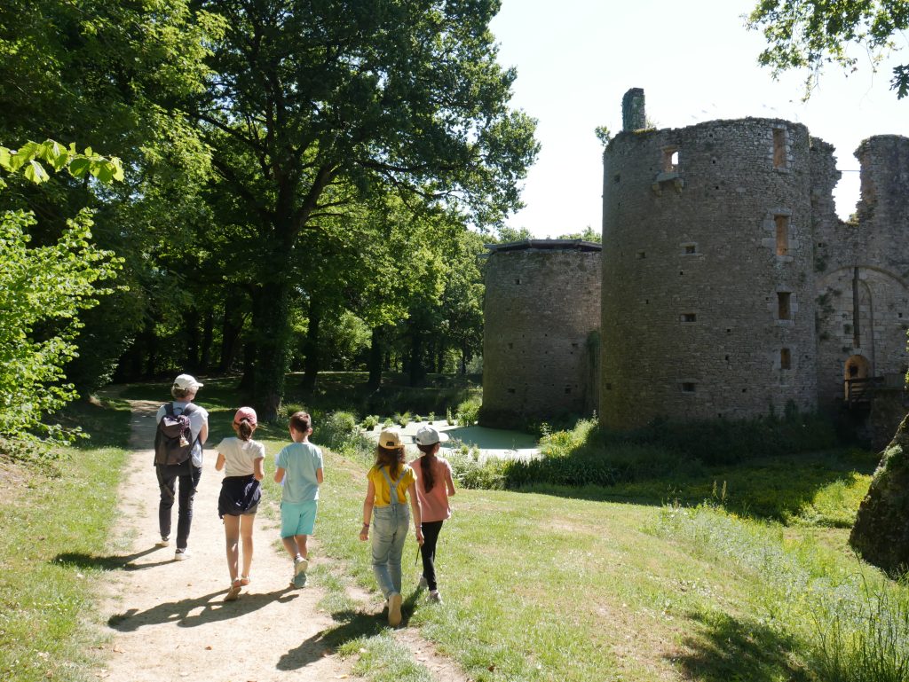 Une famille marchant autour du château en utilisant le questionnaire-jeu de médiation.